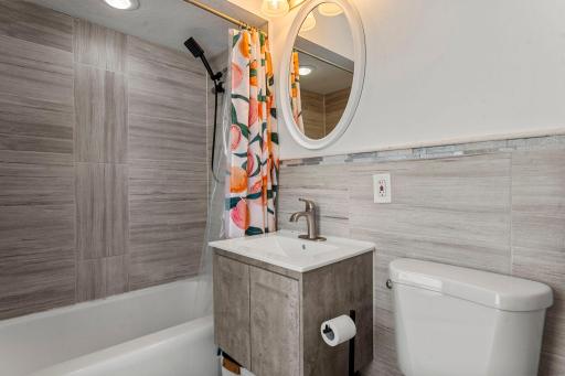 Private ensuite bathroom with a sleek, modern vanity and a tub/shower combination.
