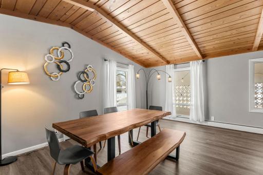 Adjacent to the kitchen is a generous formal dining area with a wood-paneled ceiling and luxury plank flooring.