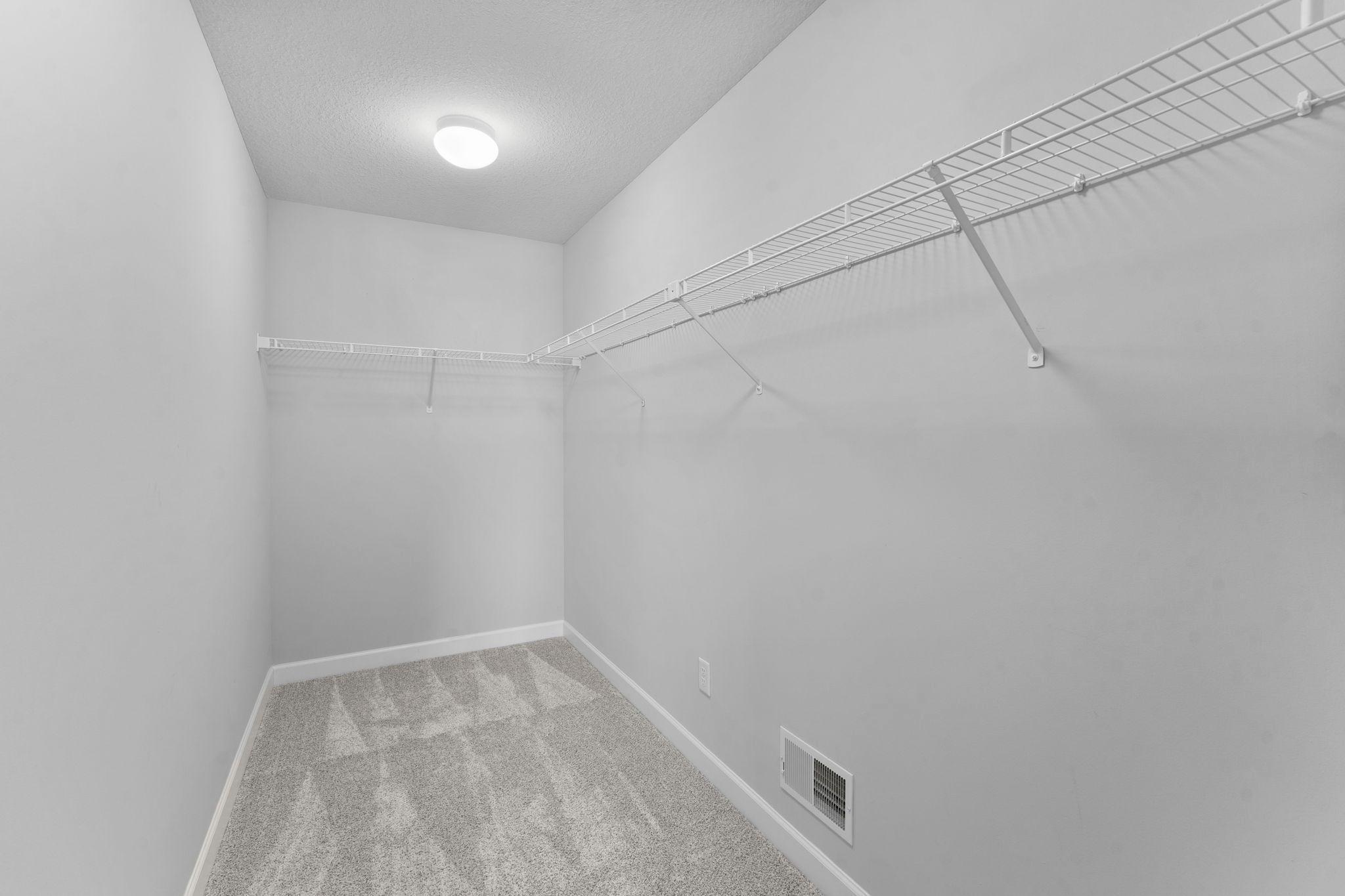 The spacious 13x5 primary walk-in closet offers ample storage and organization.