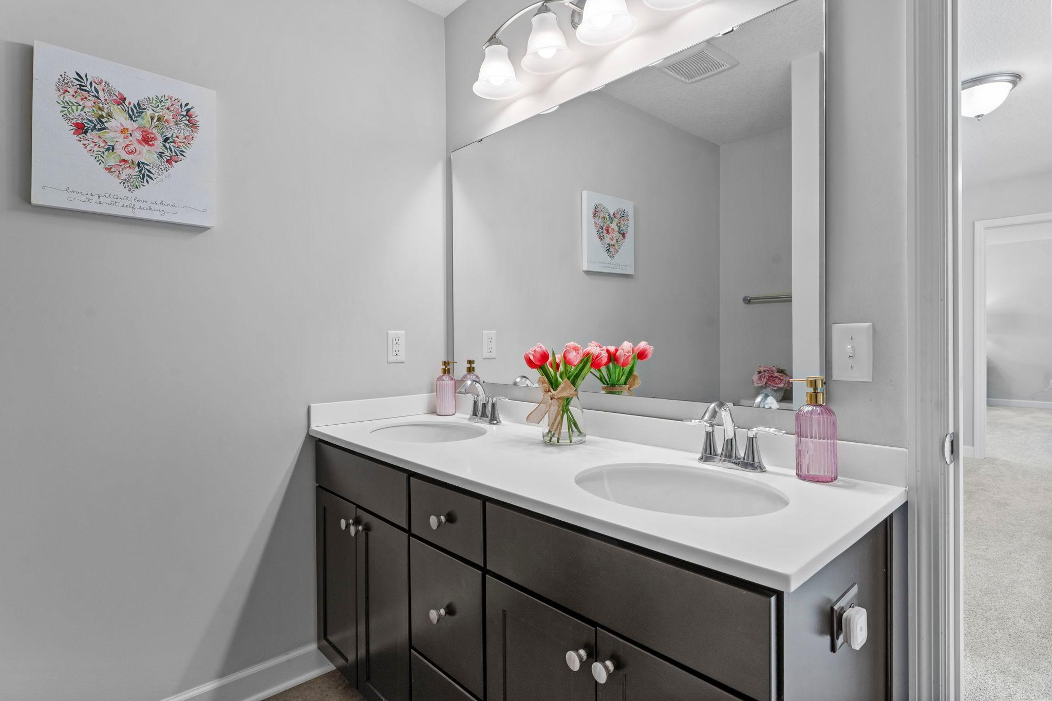 The upper-level bedrooms share a full bathroom with dual sinks and a tub/shower combination.