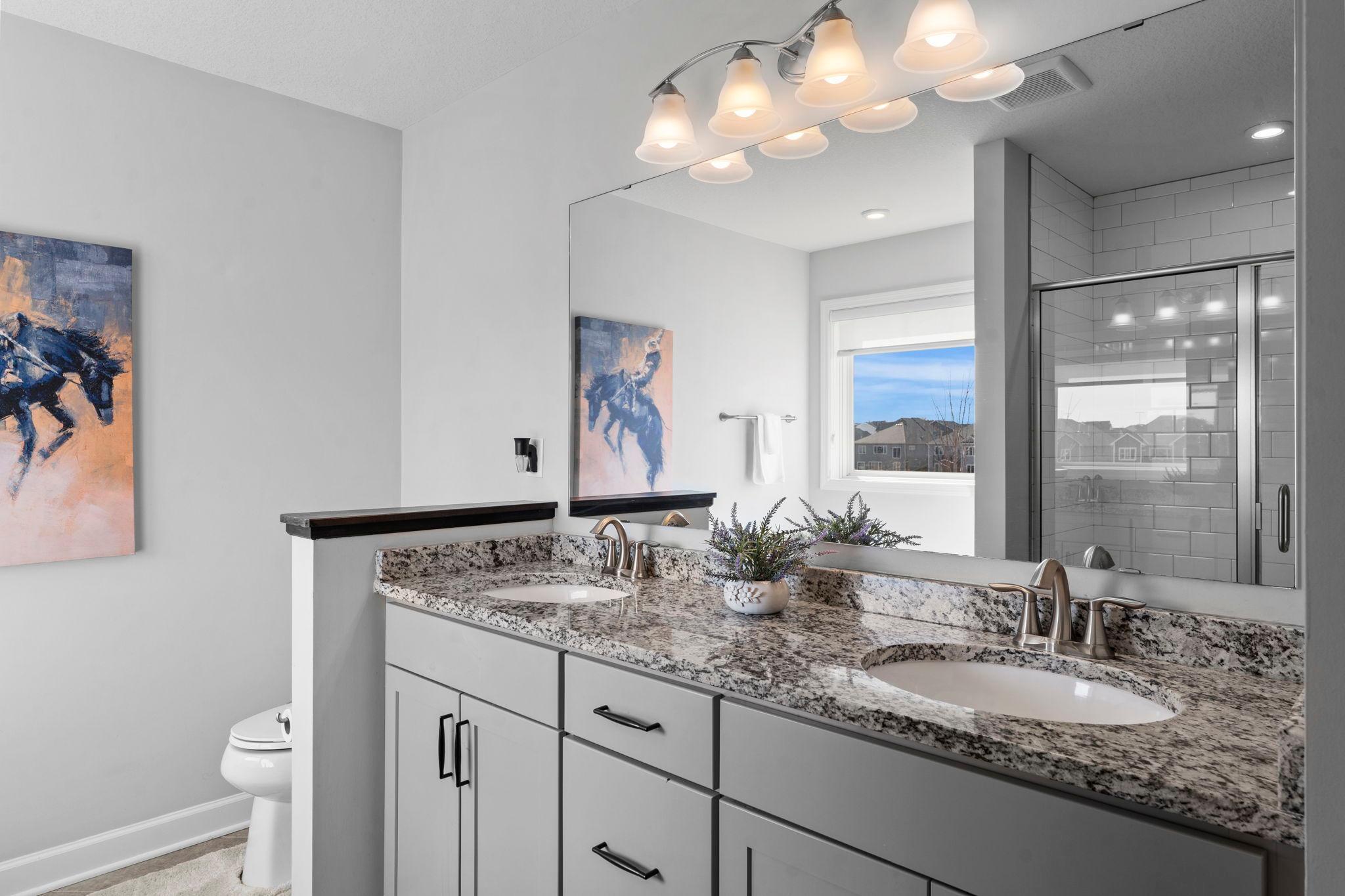 The primary private bath features dual granite vanities, a soaking tub, and a walk-in tile shower.