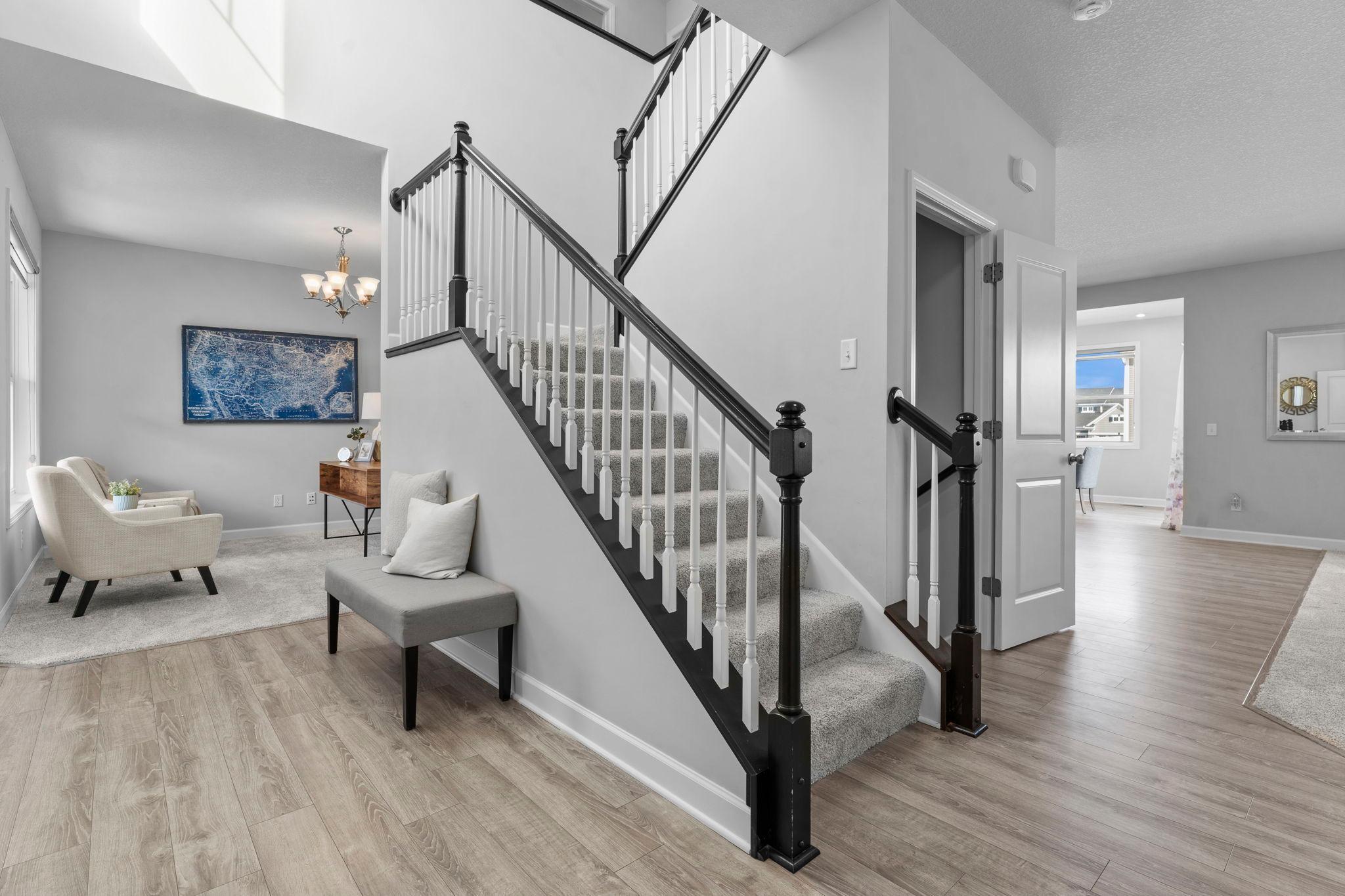 An inviting foyer featuring an 18-foot ceiling and a staircase leading to the upper level.