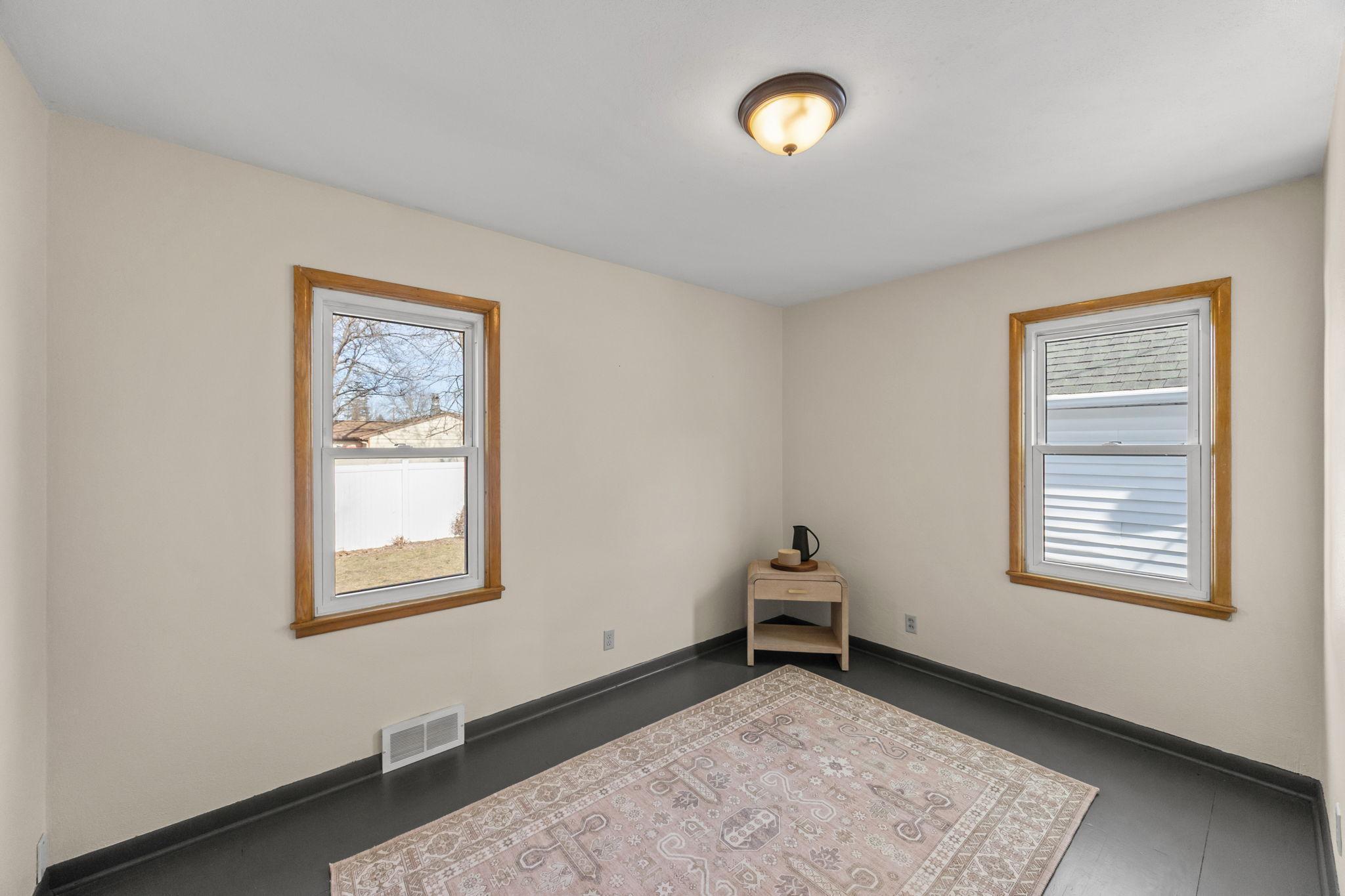 Second bedroom on the main level featuring oak hardwood floors.