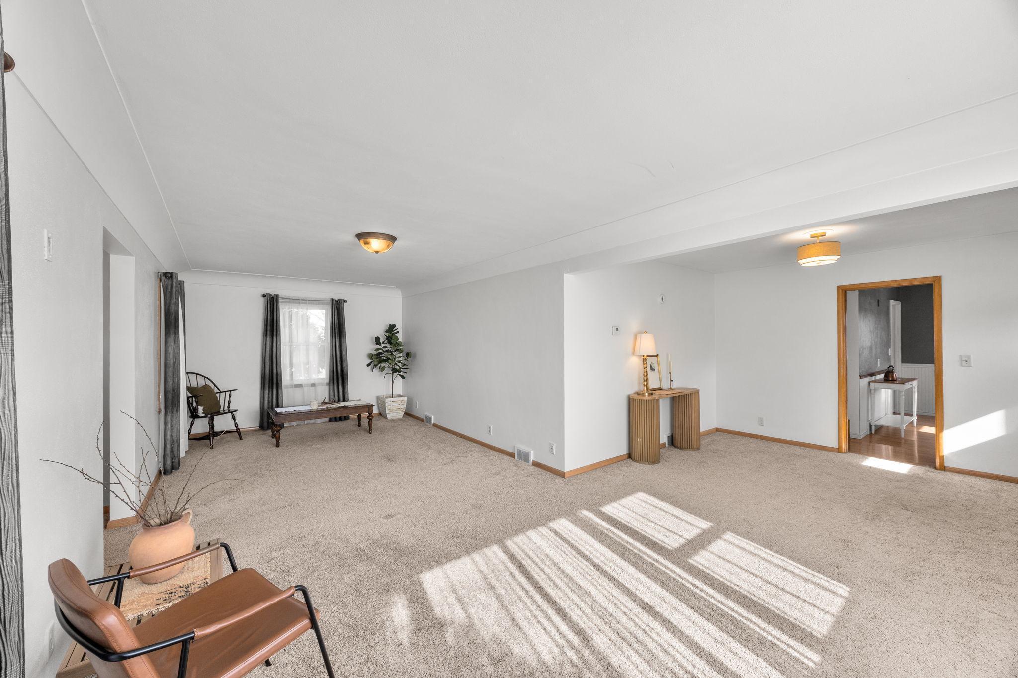 The spacious living room is bathed in natural light from its large windows.