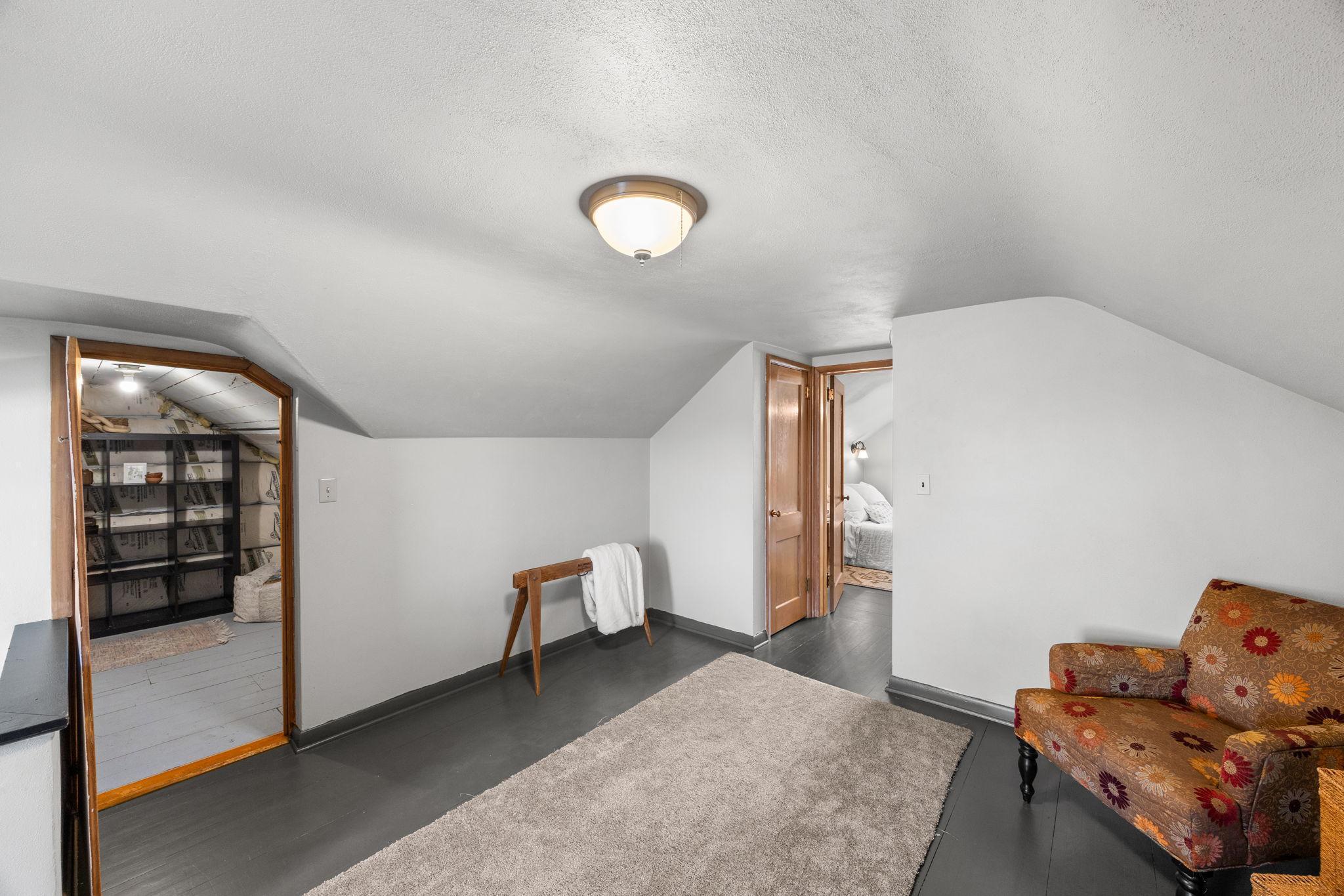 The expansive primary suite upstairs serves as a private retreat, offering a generous sitting area or versatile living space, with direct access to the walk-in closet and the bedroom’s sleeping area.