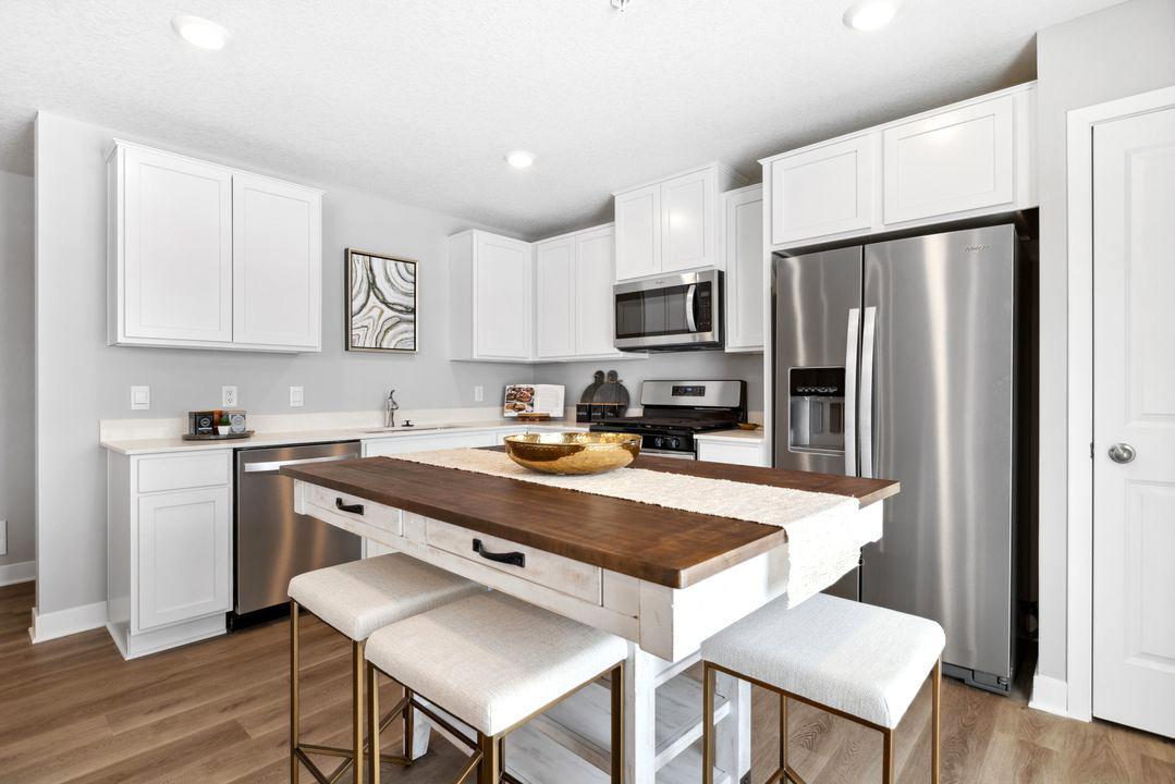 Enjoy white cabinets, quartz countertops and stainless steel appliances. Photo of model home. Colors and options may vary.
