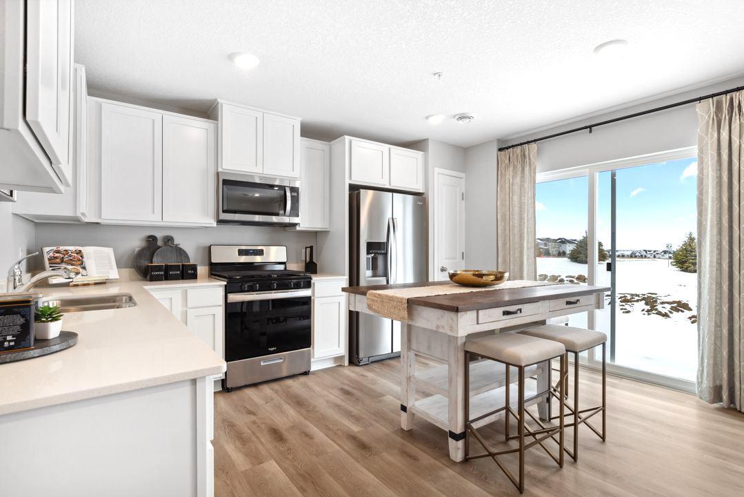 Soak in the natural light and access to your private patio right from your kitchen. Photo of model home. Colors and options may vary.