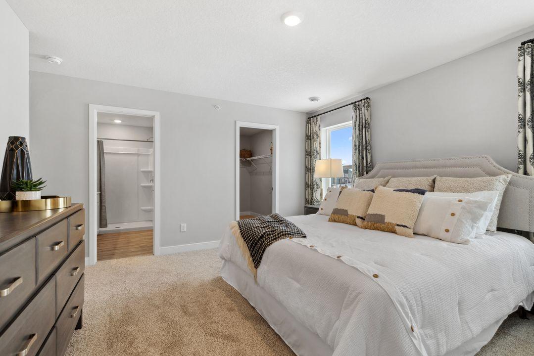 Immediate access from primary suite to full bath and spacious walk-in closet. Photo of model home. Colors and options may vary.