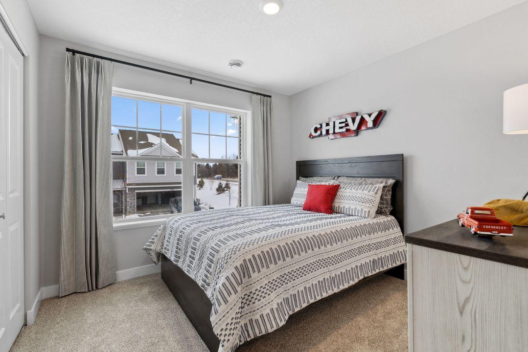 One of two spacious secondary bedrooms upstairs. Photo of model home. Colors and options may vary.