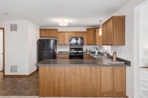 There is a black appliance set and a new stainless sink and faucet.