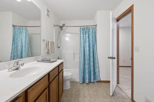 The primary bath has a long vanity and tub/shower combination.