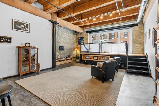 Wonderful Great Room. Exposed brick, 14' beamed ceilings, PVF flooring throughout and access to the loft alcove, in-home storage below the raised loft. Paver patio access for atop the loft.