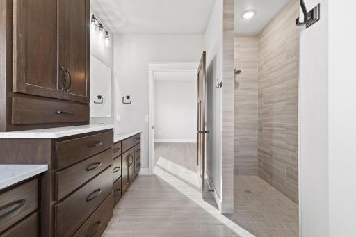 The roll-in shower features floor-to-ceiling tile, offering a sleek, modern look with ultimate convenience.