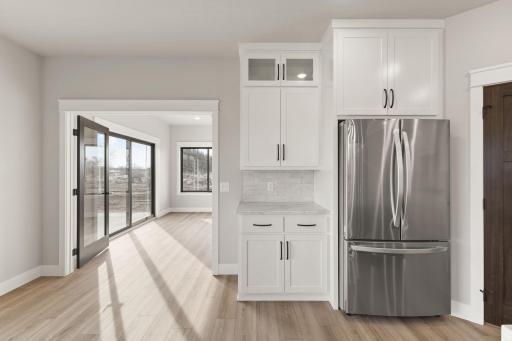 Additional cabinetry surrounds the refrigerator, offering extra space for all your kitchen essentials and keeping everything organized.