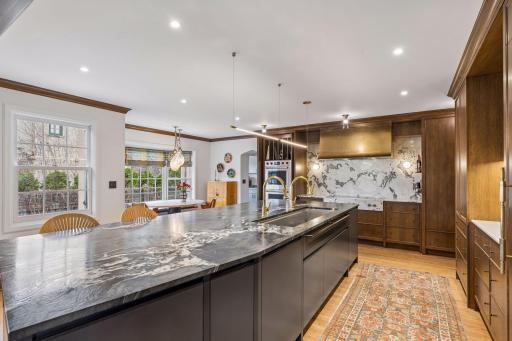 Expansive 13' center island with seating, beverage drawers, two Miele dishwashers, a 5' sink with dual facets, Subzero refrigerator and separate freezer, excellent storage, exceptional cabinetry, and designer details.