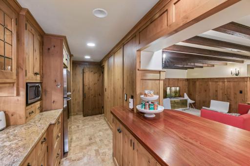 Second kitchen with full sized refrigerator, microwave, dishwasher, and sink. Bar seating with views to rec room.