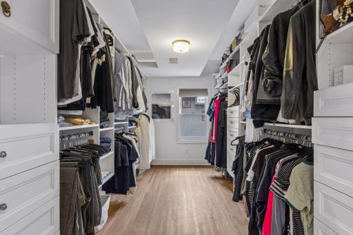 Primary suite walk-in closet with custom shelving and storage.