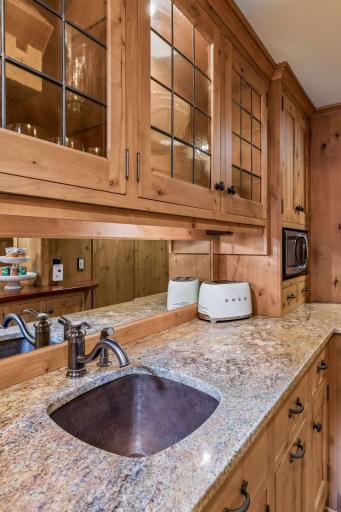 Lower level kitchenette and wet bar. Beautiful wood cabinetry and excellent storage.