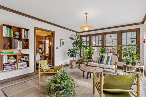 The sunny south-facing sunroom is an ideal setting for plants and an inviting sitting area with views and direct access into the backyard. The new tile and terrazzo floors are heated.