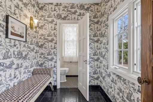 Discreet main level powder room and lounge area off of the front entry hall. This is one of two main level powder rooms. The second is located off of the mudroom and back entry hall.