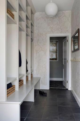 Dreamy mud room just off of the 2.5 car attached garage with stone tile floors and an adjacent powder room. Side door access to the private driveway.