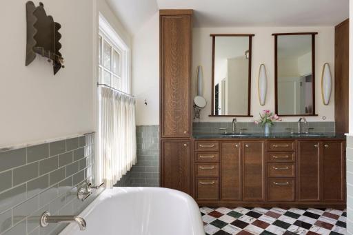 Primary en suite bath: The Water Monopoly cast-iron tub was imported from London. Double vanity with marble counters. Marble tile flooring.