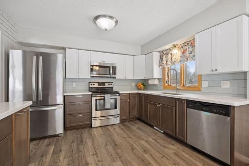 Sunfilled kitchen with quartz counters and stainless appliances