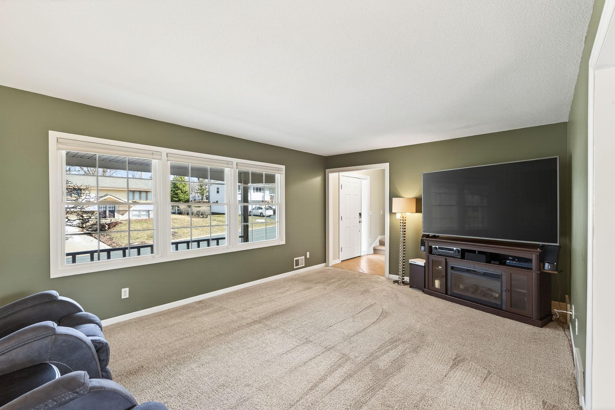 This expansive block of windows floods the living room with natural light and offers a picturesque view of the award-winning front gardens.