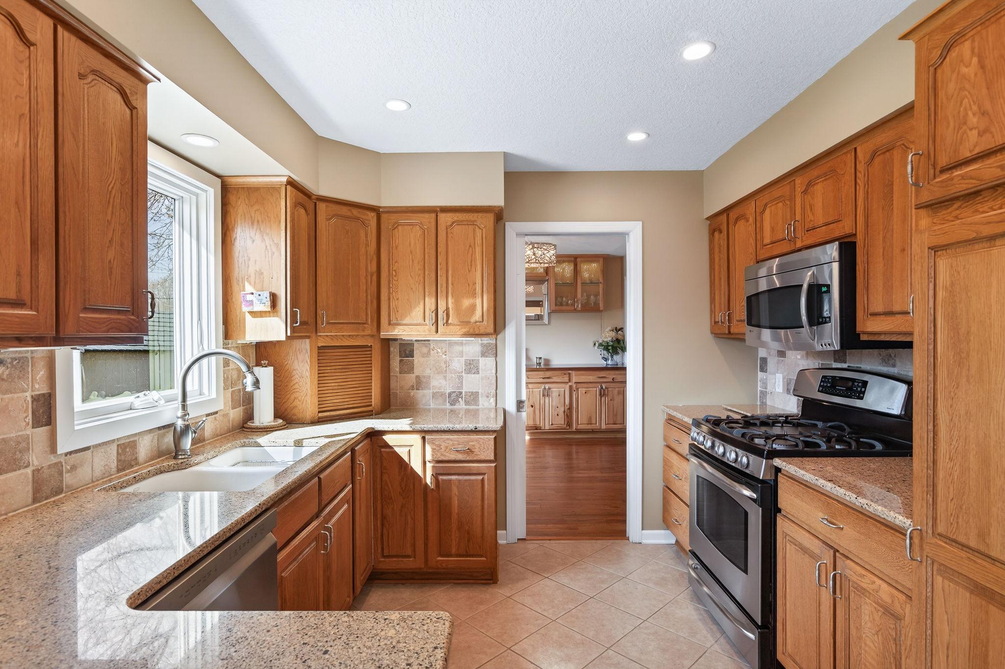 This bright kitchen features granite countertops, sleek stainless steel appliances, and a perfectly placed window overlooking the backyard oasis.