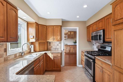 This bright kitchen features granite countertops, sleek stainless steel appliances, and a perfectly placed window overlooking the backyard oasis.