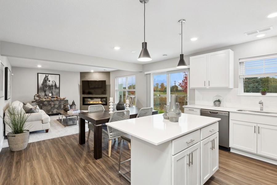 (Photo of decorated model, actual home's finishes will vary) Open main level flowing from entry area to kitchen to dining to family room.