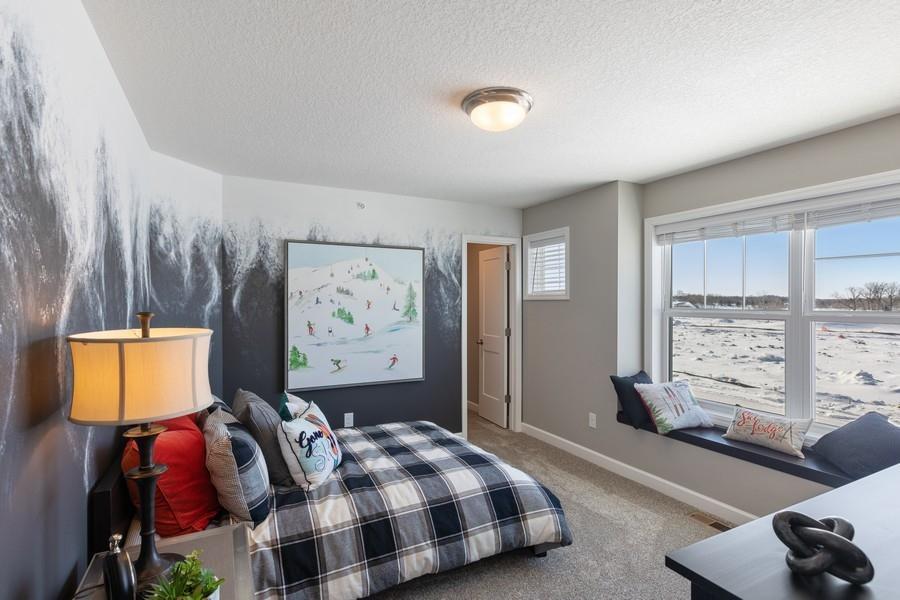 (Photo of decorated model, actual home's finishes will vary) One of the secondary bedrooms with a spacious closet!