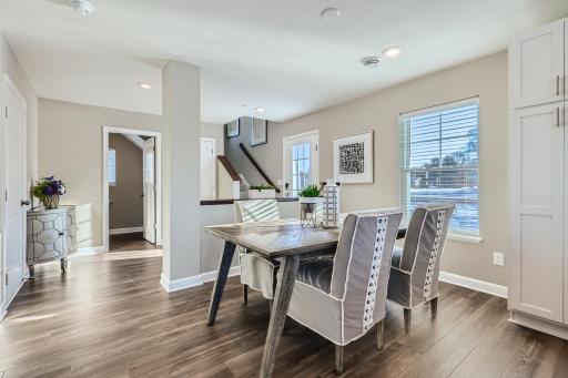(Photo of a decorated model, actual homes finishes will vary) Situated conveniently next to the kitchen is a dining room with a comfortable setup for a table and chairs.