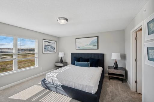 (Photo of a decorated model, actual homes finishes will vary) The spacious owner's suite is large enough for a king-sized bed and accessories.