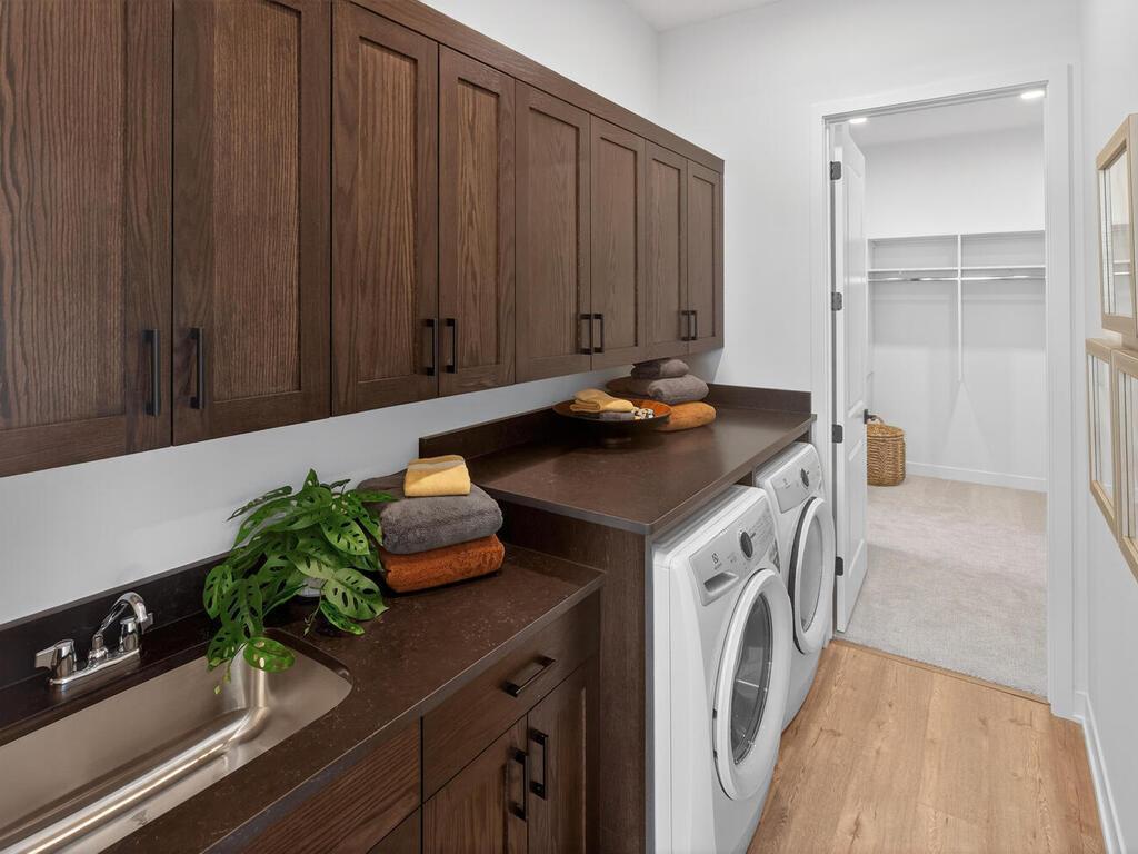 Laundry Room- built-in laundry sink, base and upper cabinets, and quartz countertop above appliances