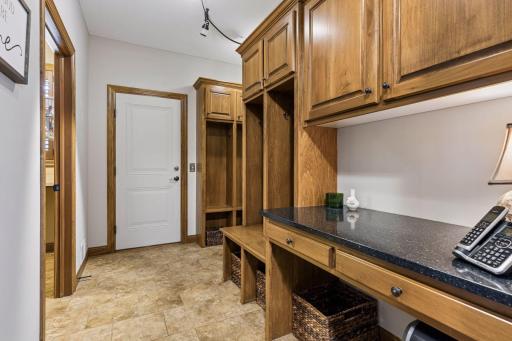 A well-designed mudroom off the garage features open lockers and a spacious closet, complemented by a main-level laundry room and an additional lower-level laundry area for lake use.