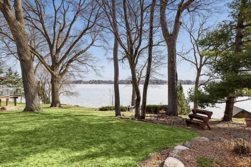 The lawn extends toward the water, offering space for gatherings, games, or relaxed time by the lake.