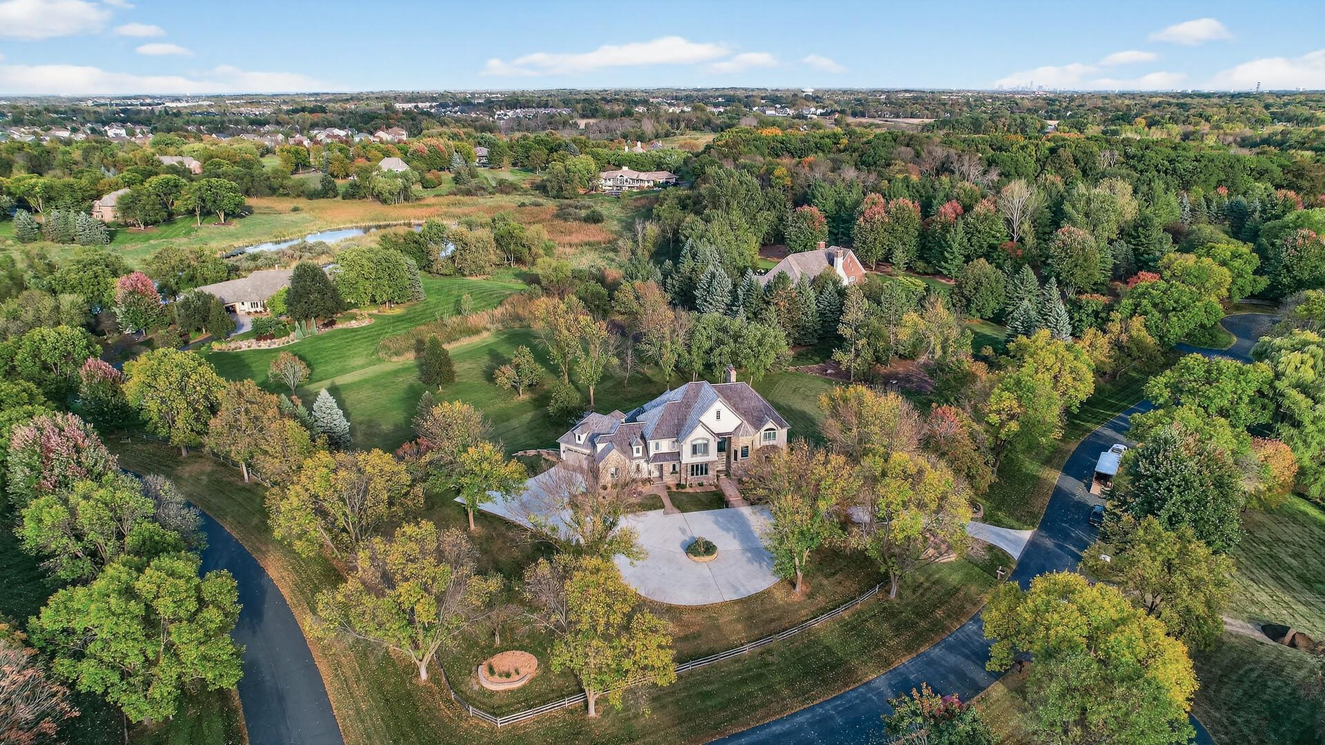 As you arrive, you’re greeted by an impressive circular concrete driveway, complemented by stamped concrete walkways that guide you to the grand brick-and-stone exterior.