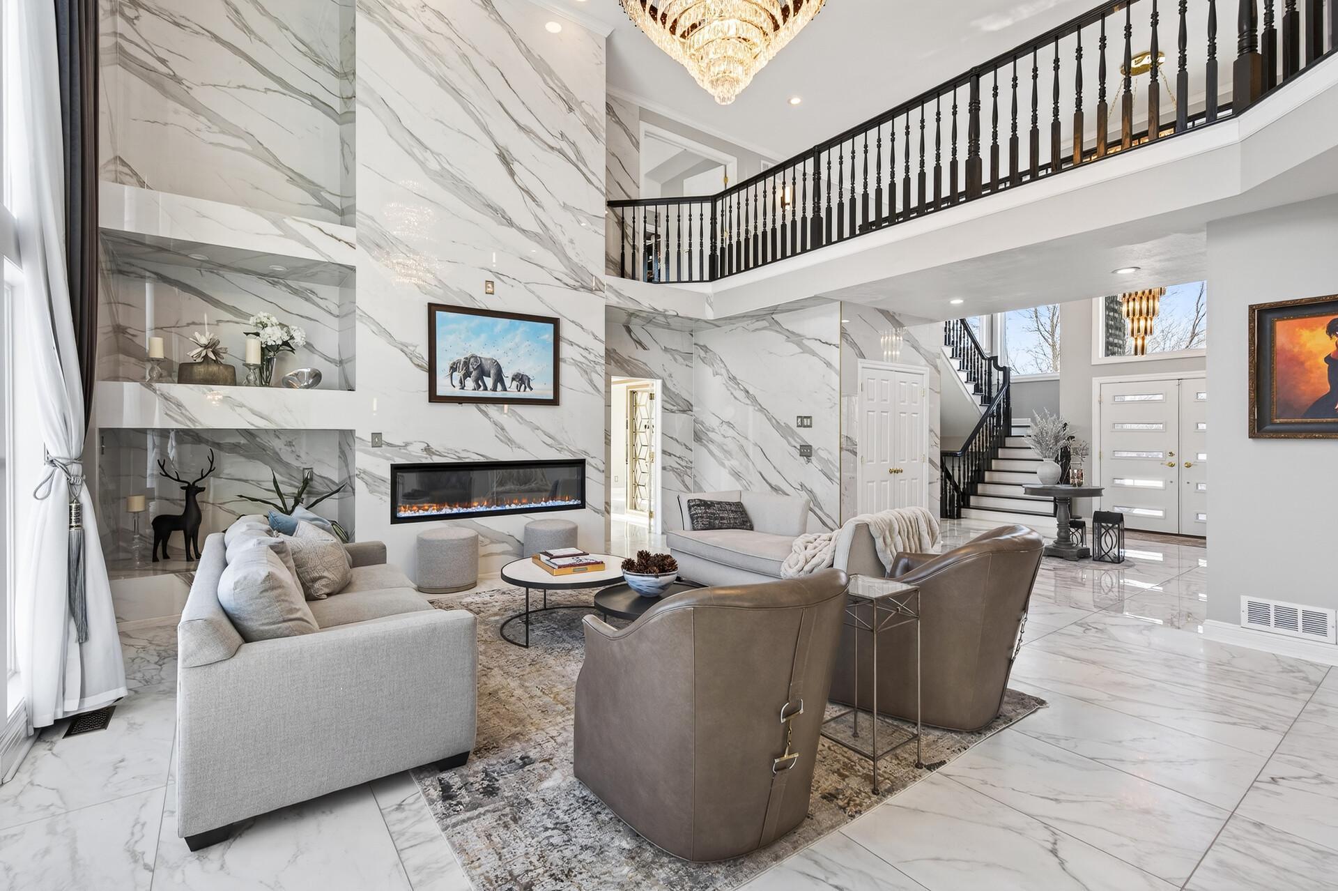Straight ahead, the show-stopping family room impresses with its expansive 18-foot ceilings and dramatic floor-to-ceiling windows, filling the space with natural light and offering beautiful backyard views.