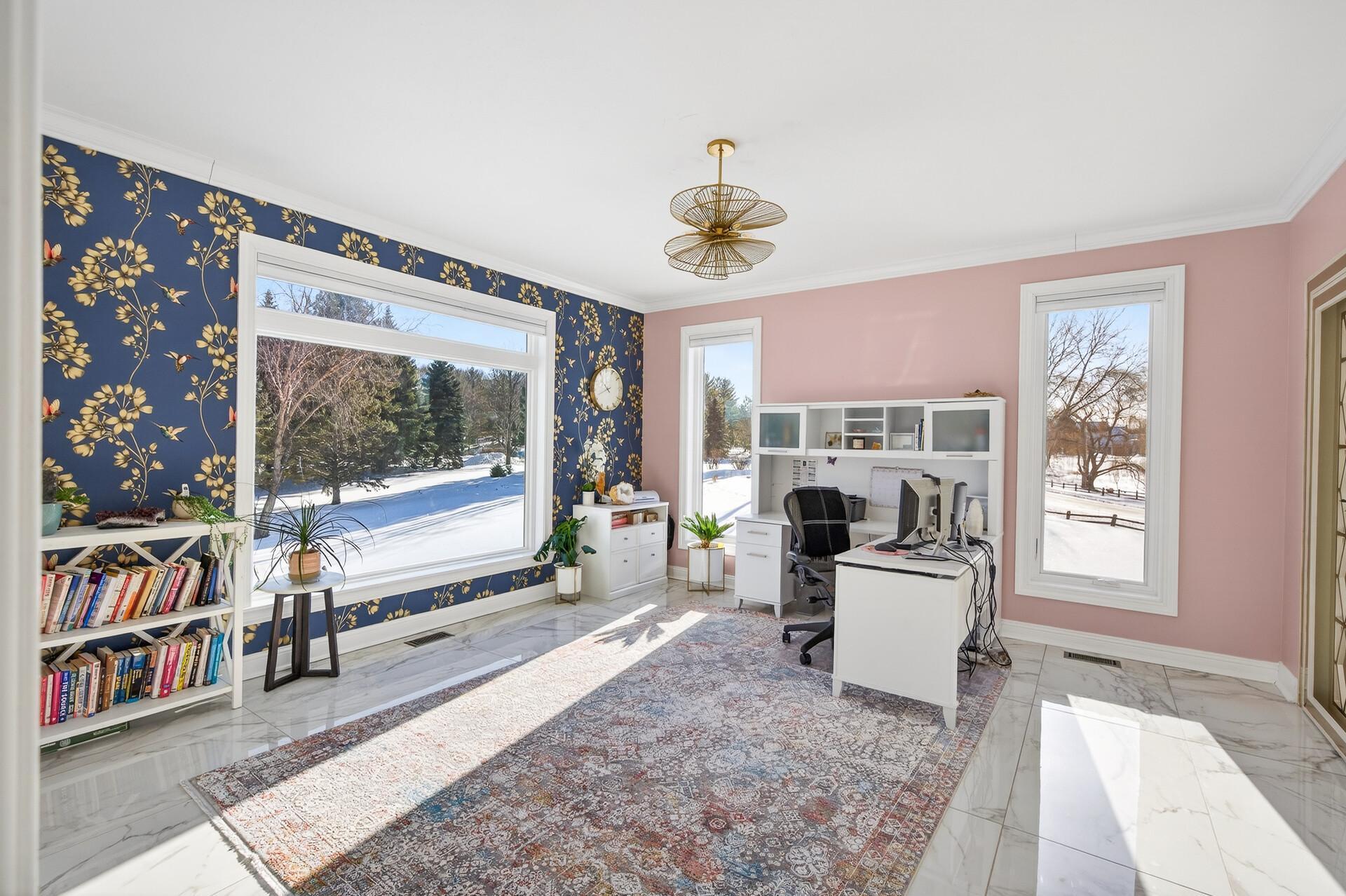 The main-level office features a cozy double-sided fireplace shared with the family room, showcased by a full-height marble surround.