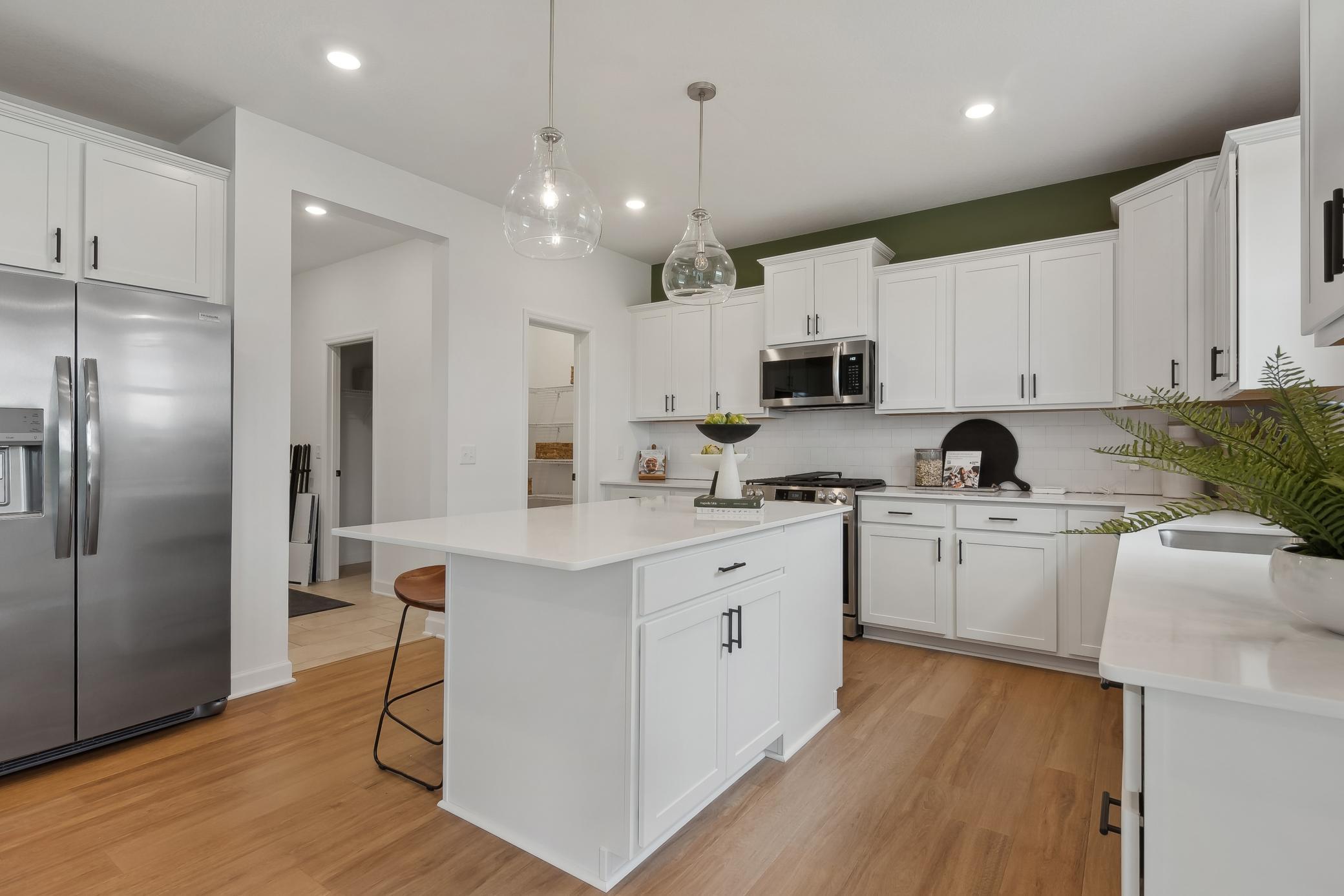 (Photos of model home, features will vary) This stylish gourmet kitchen showcases a large center island, Shaker-style cabinetry, and brand-new stainless-steel appliances.