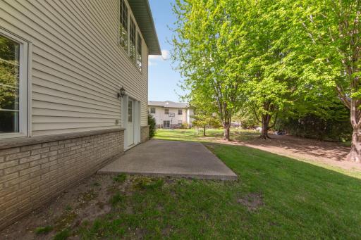 Walkout lower level to backyard with cement slab for grilling or a seating area. Notice the brick detail even on the back of the home!