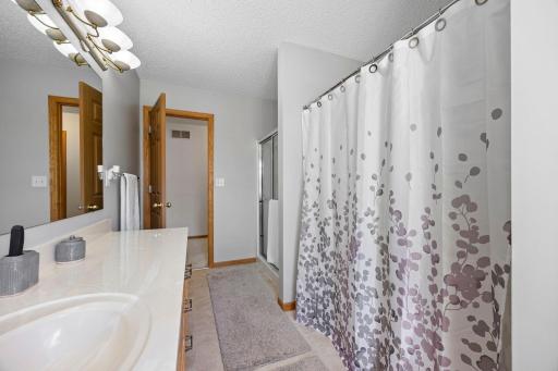 An oversized shared full bathroom offers both a walk-in shower and a tub/shower combination with tile surround, along with a vanity featuring extended counter space for added convenience. Upper-level laundry for enhanced daily routines!