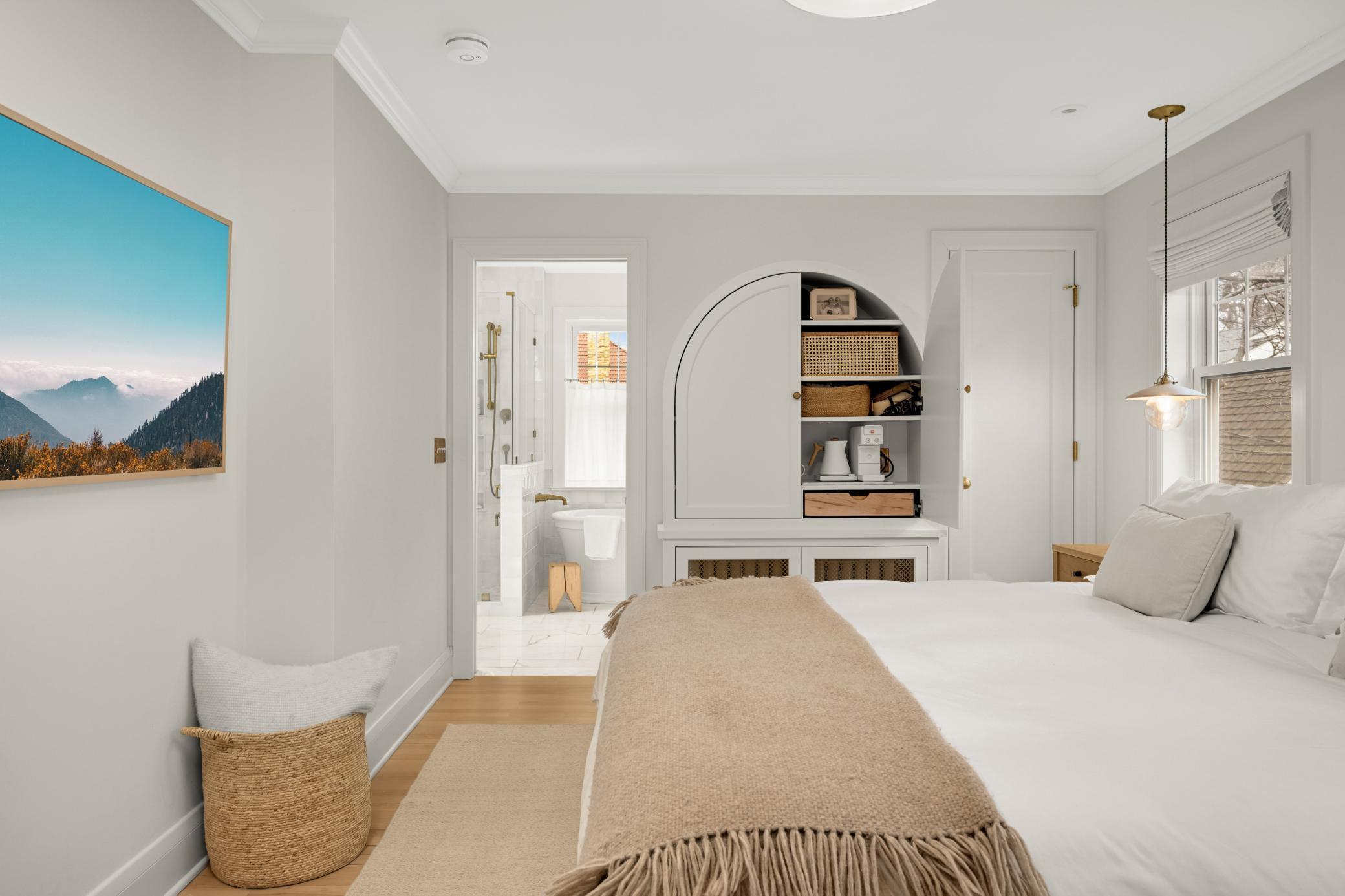 Primary bedroom offers custom built-in over the radiator with integrated electric tea and coffee station