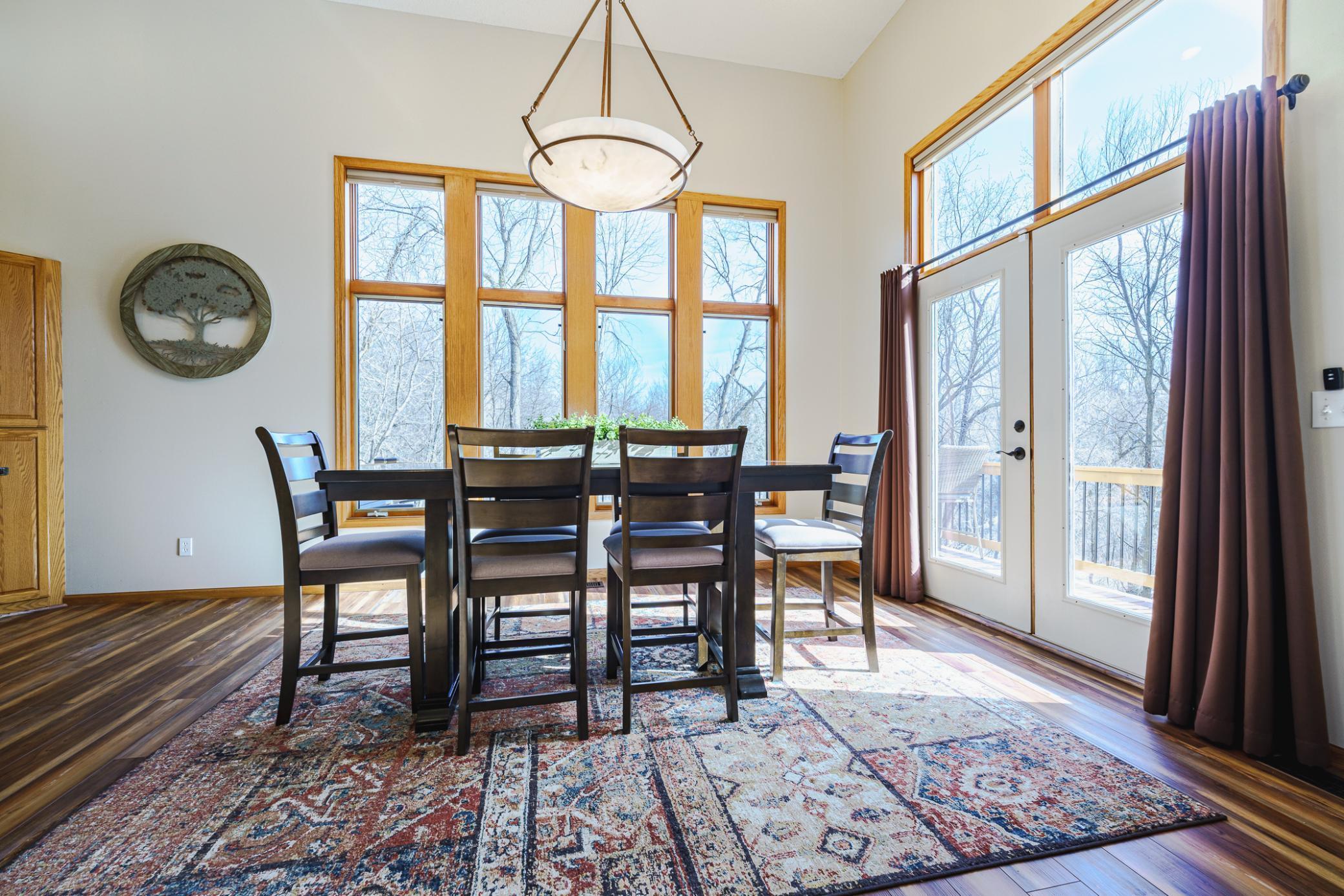 The kitchen opens to the dining room with walls of windows and a door to the wraparound deck.