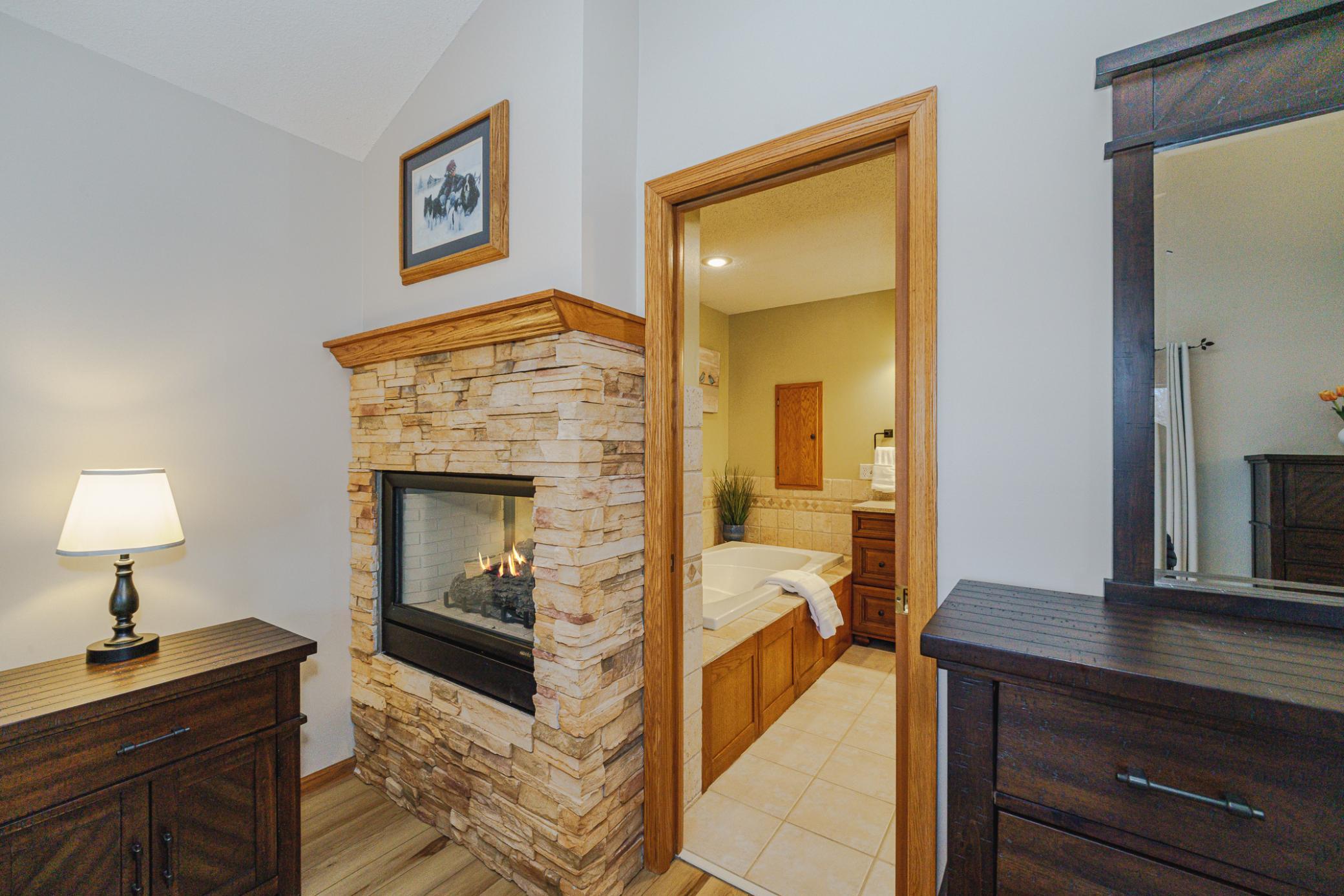A full private bathroom is adjoined and separated via a pocket door. A 2-sided fireplace with dry-stack stone separates these two spaces.