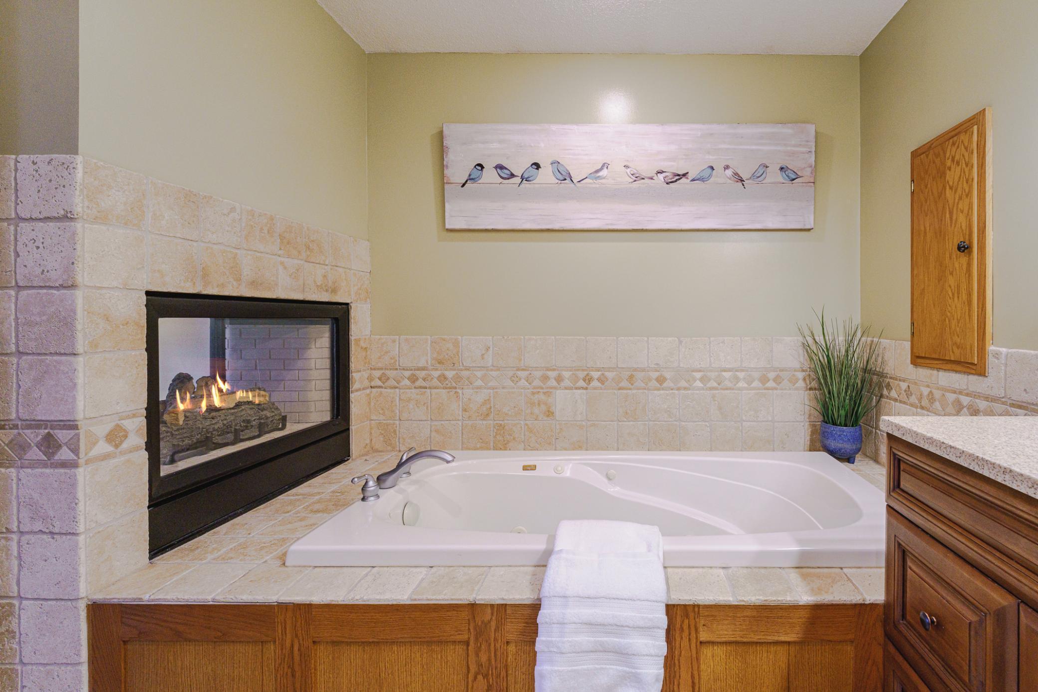 Here you can see the see-through fireplace shared between the bedroom and bathroom.