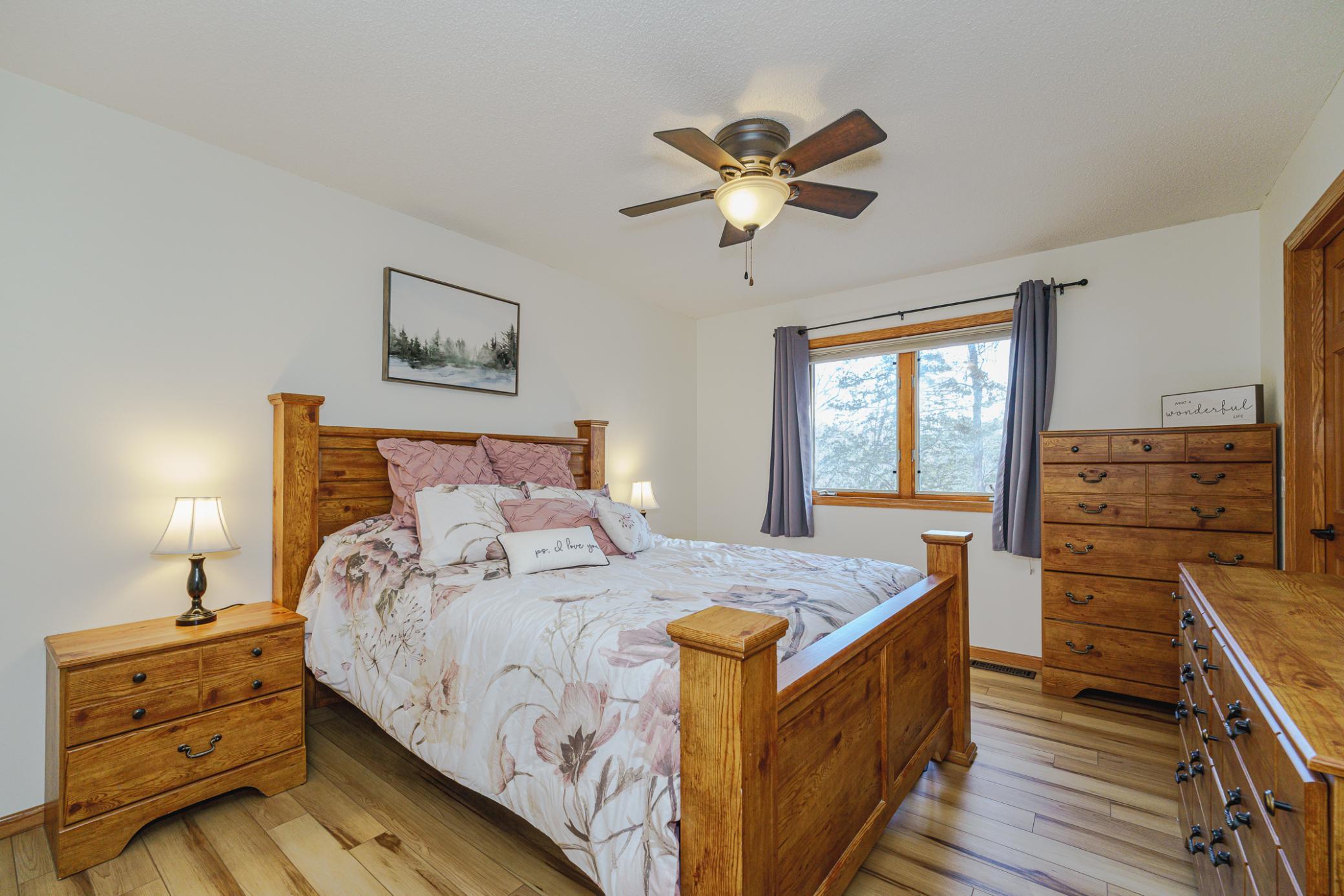The additional upper-level bedroom has a walk-in closet and a ceiling fan.