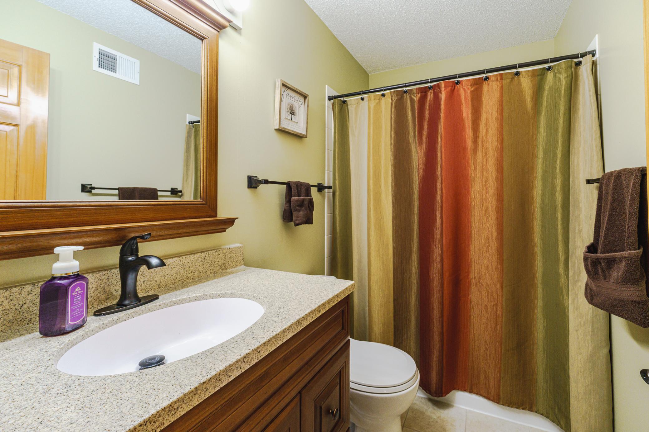 The upper-level full bathroom features an elevated height vanity with granite top and tile flooring.