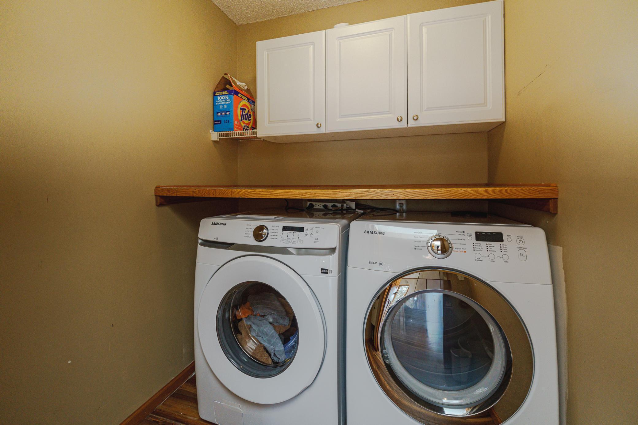The laundry room has a new washing machine as of March 2026, a folding counter, and cabinets.